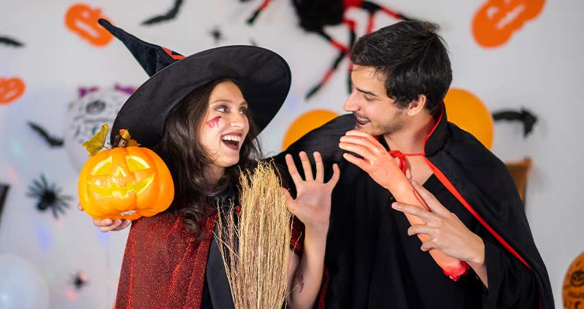 Um casal mascarado para o halloween. ela de bruxa e ele de drácula